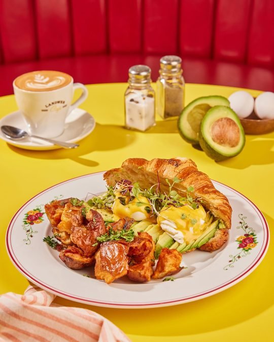 Close-up of a beautifully plated sandwich with mashed potatoes and coffee, captured on vibrant table