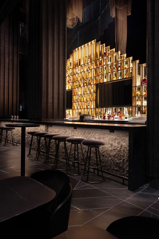 Elegant bar counter with high-end spirits and designer stools, photographed for a restaurant marketing campaign