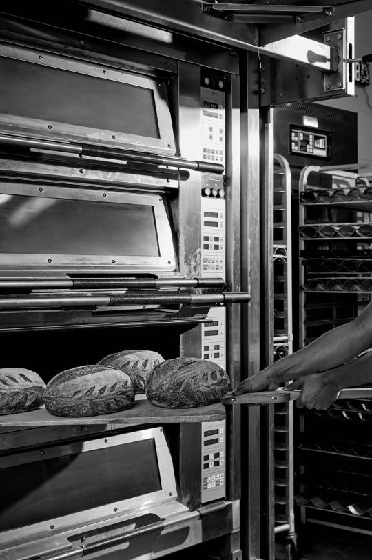 Freshly baked artisan bread on a rustic wooden board, photographed in natural light