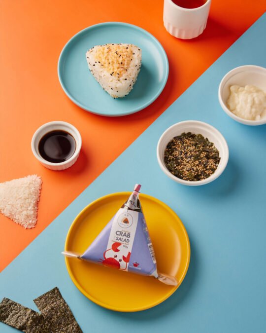 Onigiri sushi on vibrant colour with minimal styling and high-end food photography,professionally photographed.