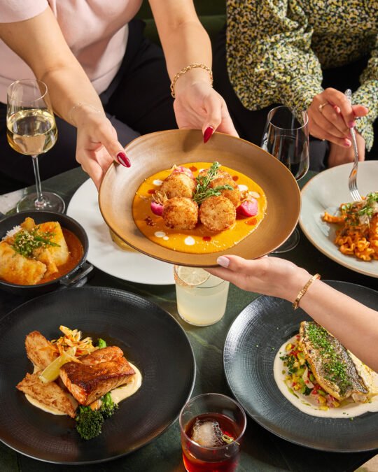 Food photography for hotel menu. Hand incorporate handing to other person showing and focus with the main dish. bright mood tone