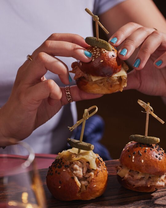 Close up of someone holding a mini burger