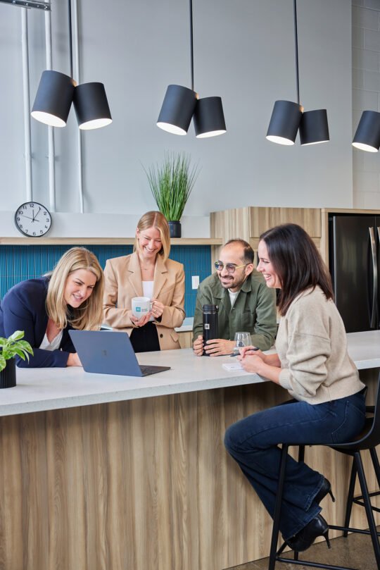 Portrait of group of people in the middle of kitchen area meeting time