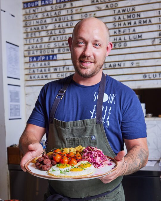 Portrait of chef showing the food in front of the counter restaurant